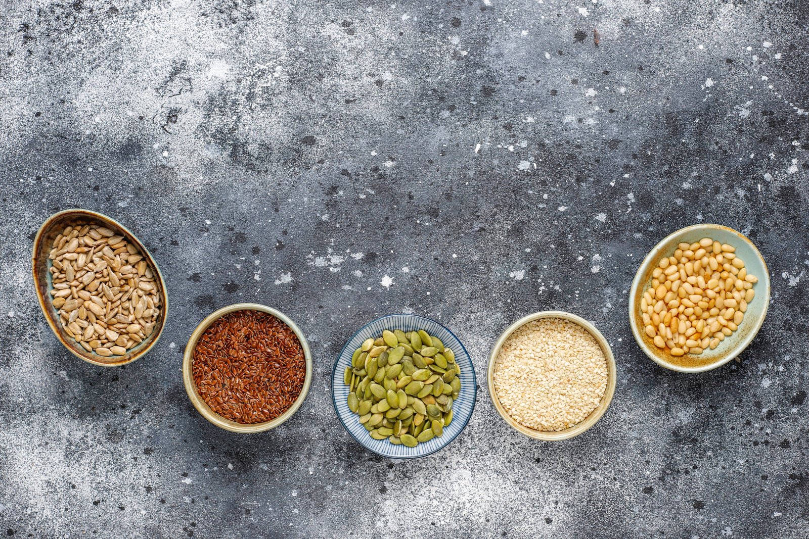 Bowls of sesame, flax, sunflower and pumpkin seeds